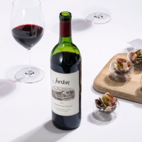 Jordan Wine bottle and glass with appetizers
